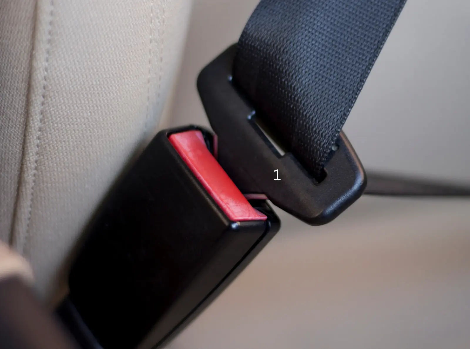 Seat belt buckle and tongue aligned side by side before engagement.