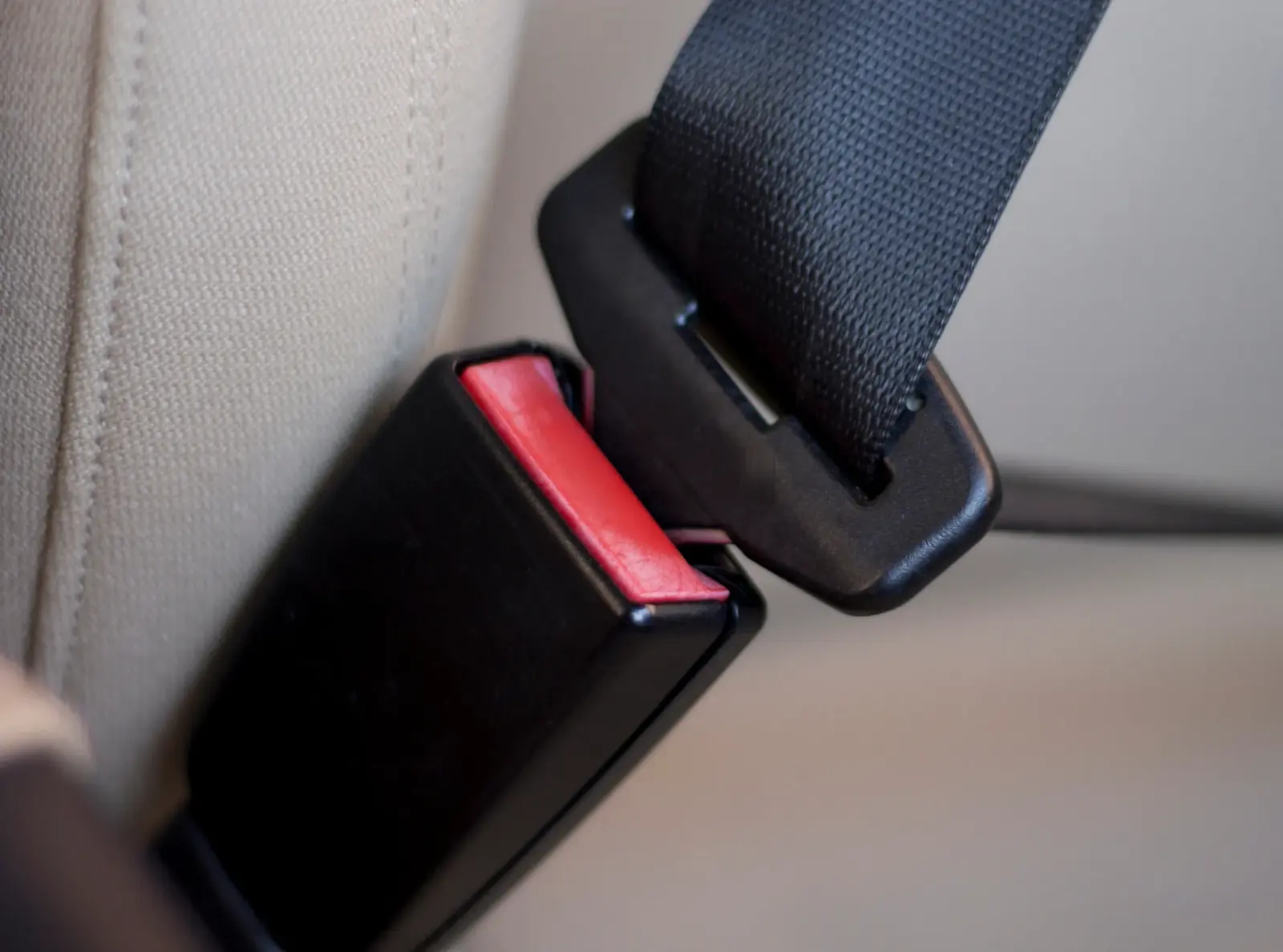 Detailed view of a seat belt buckle assembly with the latch plate positioned for engagement.